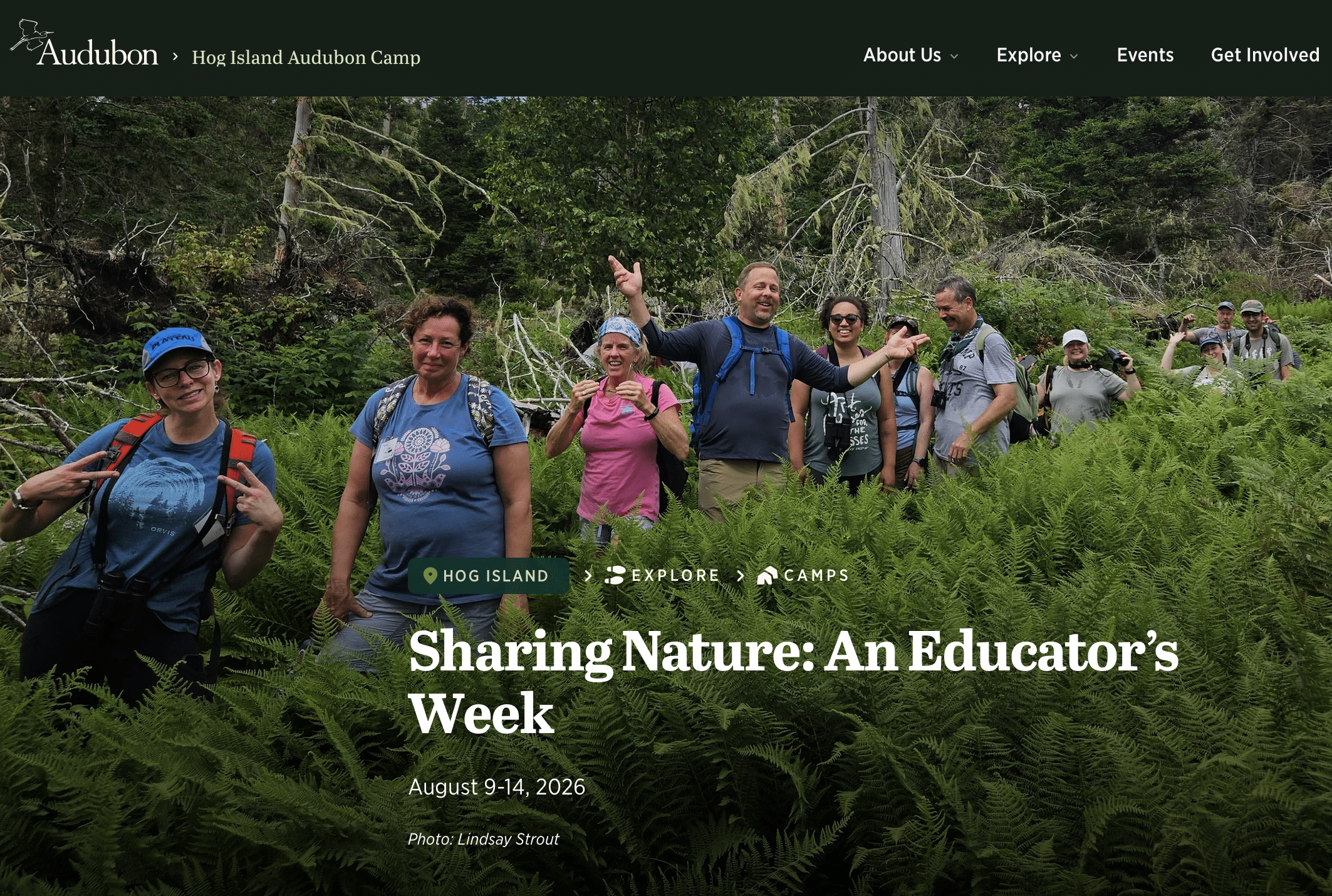 A group of smiling adults hike through green ferns in a forest. They wear backpacks and casual clothes, walking along a narrow path. Text on the image promotes an educators week camp at Hog Island, August 9-14, 2026.